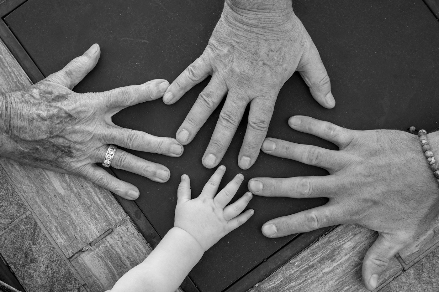 Hands of different generations reaching toward each other
