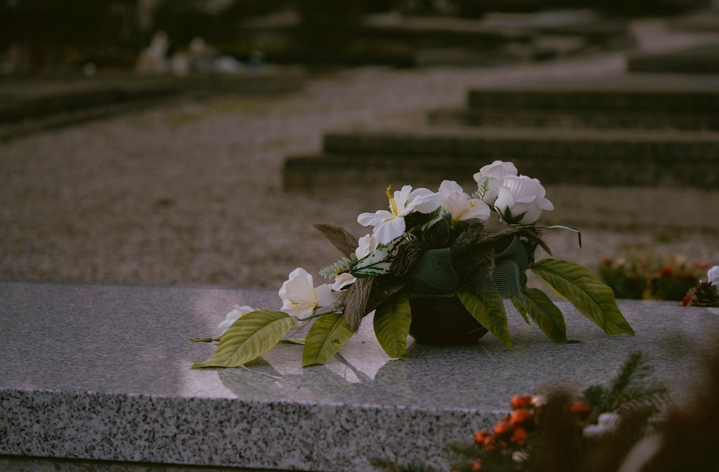 Vase of white flowers on a stone surface
